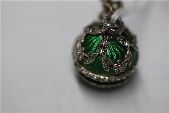 An early 20th century continental silver gilt, green enamel and diamond set ball timepiece pendant,